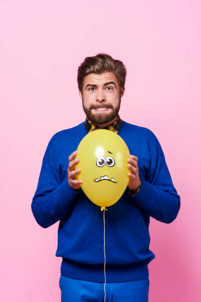 Angry man trying to squeeze a balloon Angry man trying to squeeze a balloon clenching teeth stock pictures, royalty-free photos & images