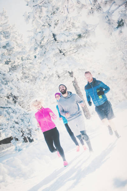 istock Four people running on snowy mountain 877325878