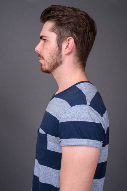 istock Young bearded handsome man against gray background 877329972