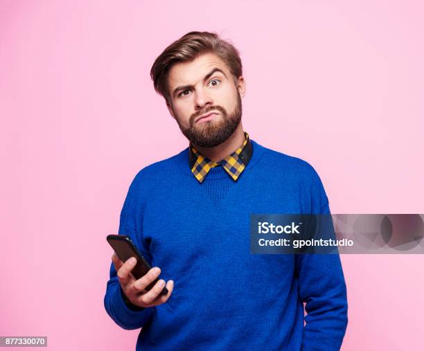 Hombre Sorprendido Con Teléfono Móvil Foto de stock y más banco de imágenes de Hombres - Hombres, Preguntar, Confusión