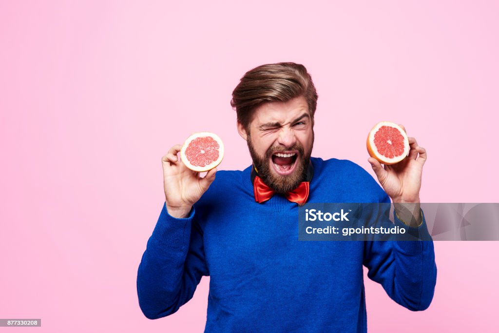 Screaming man holding sour fruit Sour Taste Stock Photo