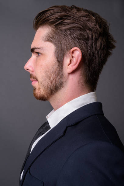 istock Young bearded handsome businessman against gray background 877330630