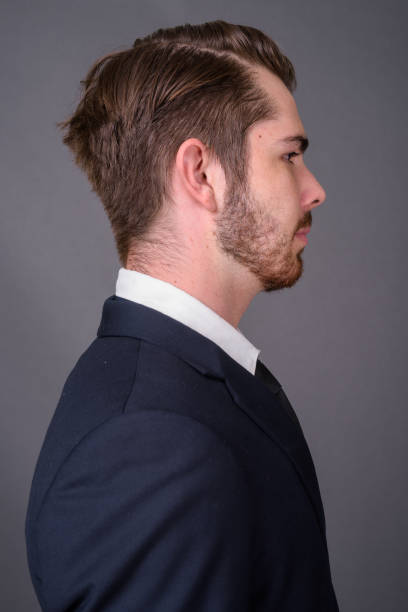 istock Young bearded handsome businessman against gray background 877330634