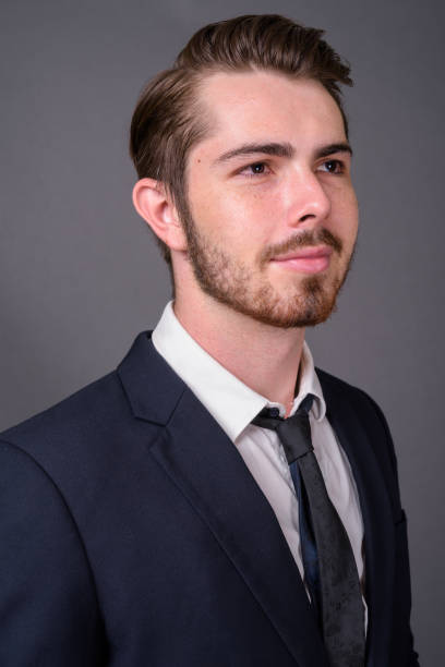 istock Young bearded handsome businessman against gray background 877330664