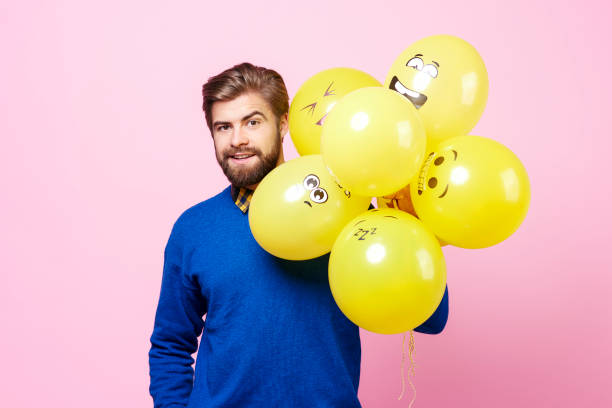 istock Handsome man holding bunch of balloons 877336926