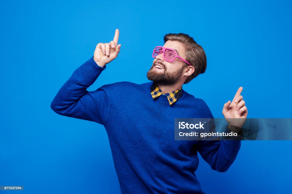 Uomo con occhiali da sole che ballano allo scatto in studio - Foto stock royalty-free di Uomini
