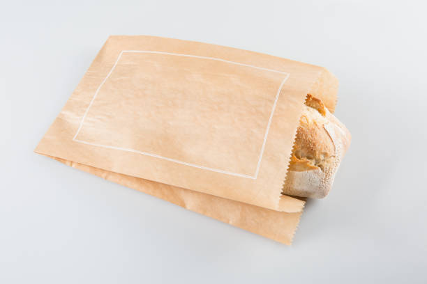 baguette in paper bag isolated on white background - papel de pão imagens e fotografias de stock