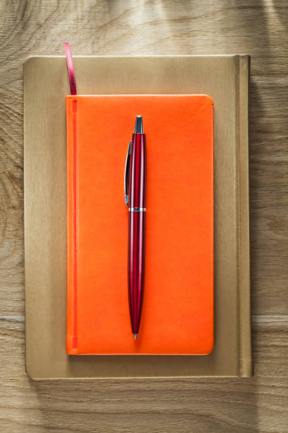 istock Closed notepads pen on wooden board 877348514