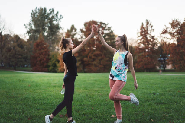 istock Two friends with ponytails giving each other high-five 877348580