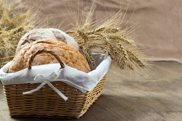 istock Two breads in a woven basket decorated with coals on a wooden table 877348920
