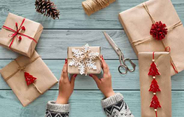 istock Woman's hands holding christmas holiday present decorated with snowflake 877356624