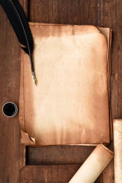 istock old paper on brown wood texture with feather and ink 877359578