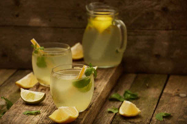 istock Homemade lemonade  in glasses on old wooden table. Selective focus. 877360552