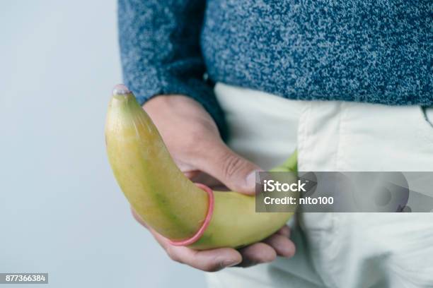 Man Holding A Banana With A Condom Stock Photo - Download Image Now - Penis, Banana, Men