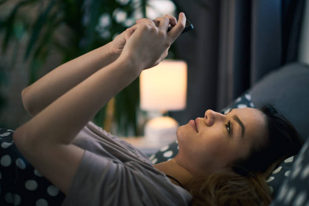 istock Girl using smart phone in bed 877370418