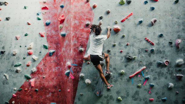 Solo Session At The Climbing Centre One young man is enjoying rock climbing in a climbing centre. toughness photos stock pictures, royalty-free photos & images