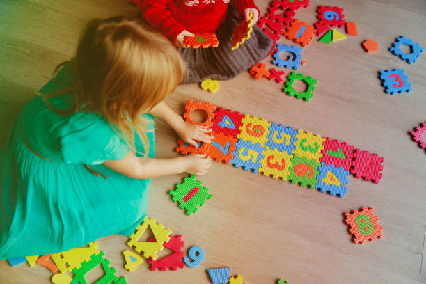 istock kids playing with puzzle, learning numbers and shapes 877371924