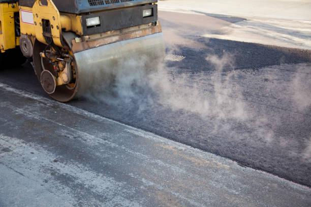 Road repairs, new layer of asphalt Yellow steamroller pressing the new asphalt surface to level it. Steam coming from hot asphalt. compactor photos stock pictures, royalty-free photos & images