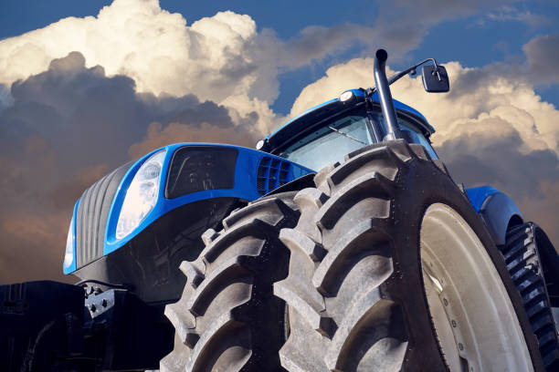 istock Agricultural tractor on sunset background 877373036