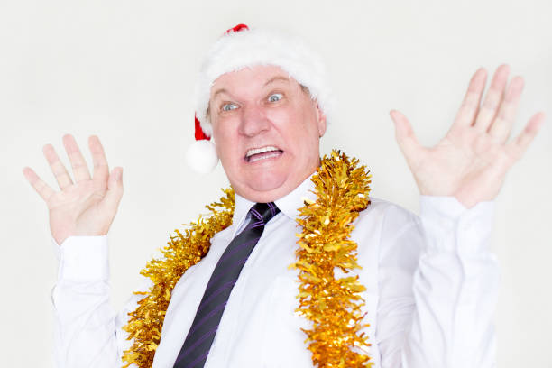 istock Scared businessman in Santa hat raising hands 877381022