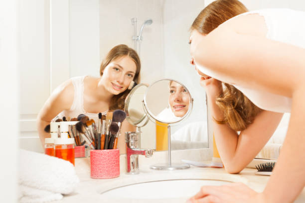 istock Beautiful young woman doing her makeup in bathroom 877382256