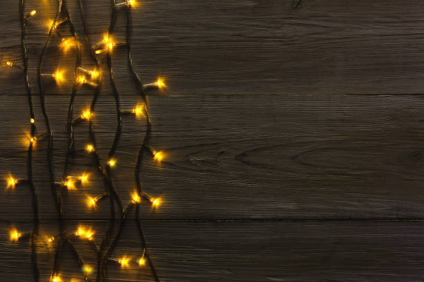 istock Christmas lights border on grey wooden background 877382760