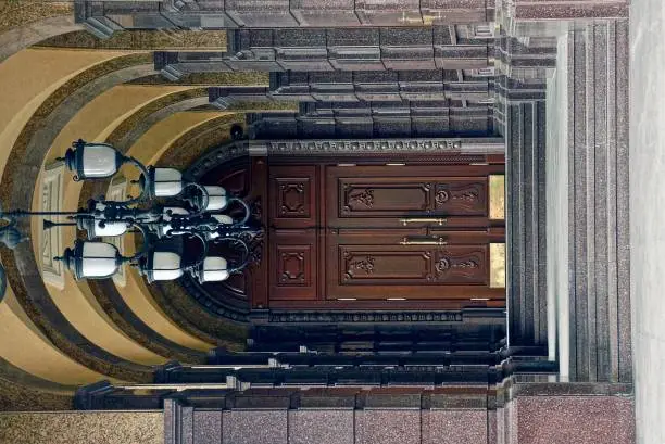 Chandeliers and a door in the marble corridor of the building