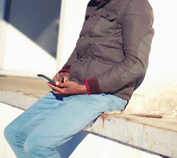 istock Man is sitting using smartphone in the city 877383436