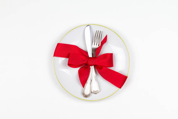 istock Christmas table place setting with plate, cutlery, pine branches,  ribbon and red berries. Winter holidays festive background 877384232