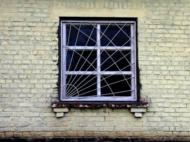 istock Old window with grille on the brick wall 877386212