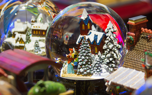 Glass balls with houses, snow-covered trees and characters inside the glass sphere