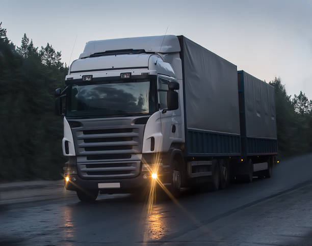 istock truck moves on highway at night 877394940