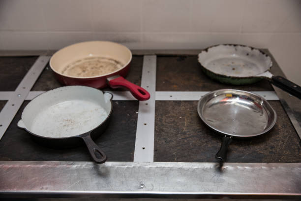 istock Four old frying pans on an old industrial plate 877395516