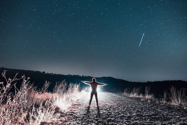 istock Man with arms raised at night 877407400