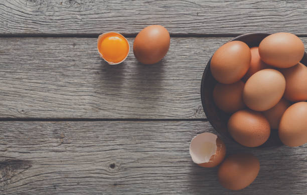 istock Brown and white organic eggs in bowl on wood background 877407694