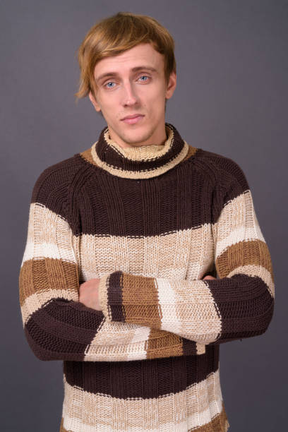 istock Young handsome man with bond hair against gray background 877441960