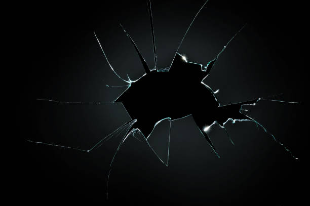 istock broken cracked glass with big hole over black background 877474766