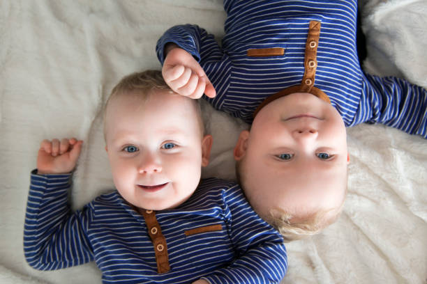 eineiige zwillinge auf dem kopf stehend - people child twin smiling stock-fotos und bilder