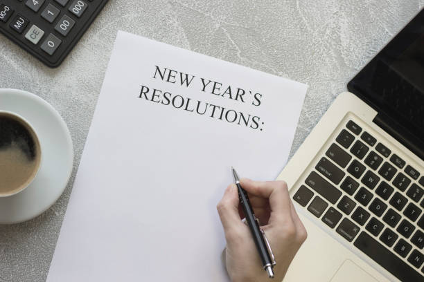 istock A hand writing New Year's resolutions, coffee, office supplies 877503802