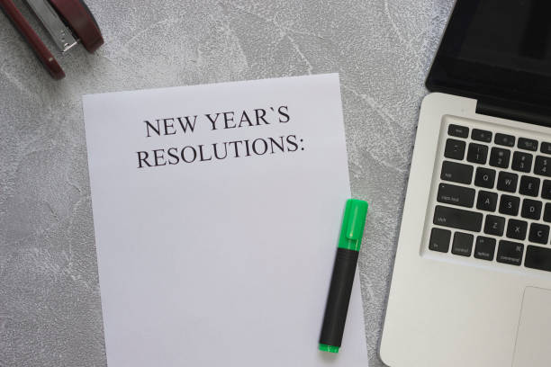 istock New Year's resolutions paper, a green highlighter, a laptop 877505234