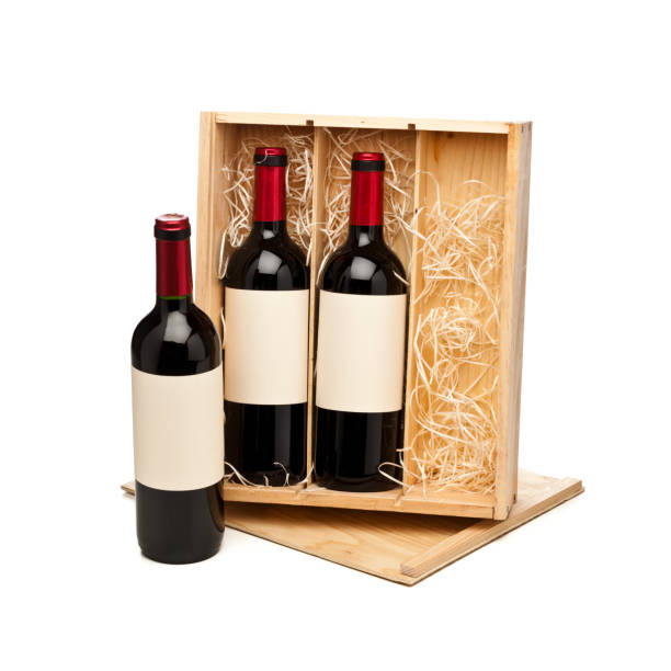 istock Opened wooden box with three red wine bottles isolated on white background 877505426