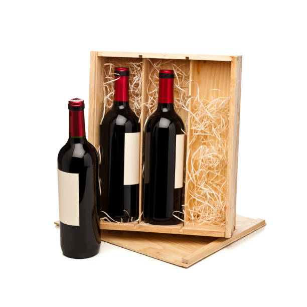 istock Opened wooden box with three red wine bottles isolated on white background 877508042