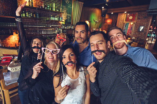 Co-worker having a new years eve party in a bar, doing photobooth