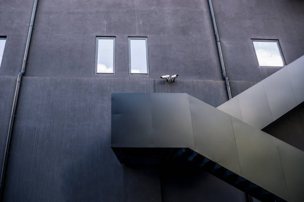istock Black metal outside staircase on industrial black facade 877520414