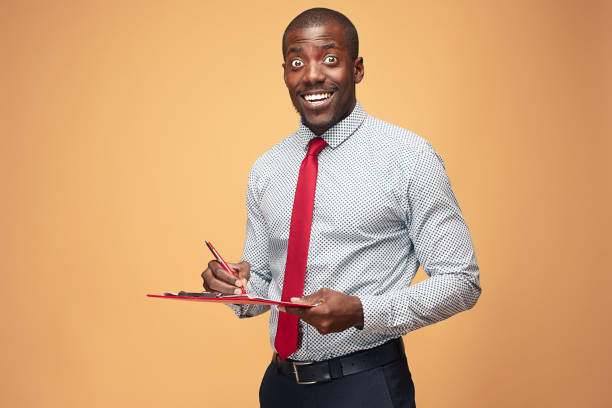 atrakcyjny stały afro-amerykański biznesmen piszący notatki - book holding necktie businessman zdjęcia i obrazy z banku zdjęć