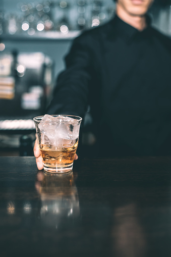 Bartender holding whiskey.
