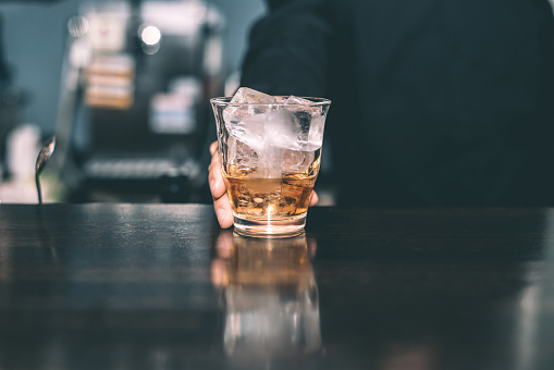 Bartender holding whiskey.