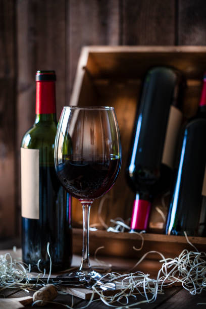 istock Wineglas and red wine bottle shot rustic wooden table 877618246