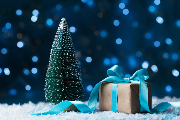istock Fir tree and gift box or present on snow background. Christmas greeting card, bokeh effect. 877633490