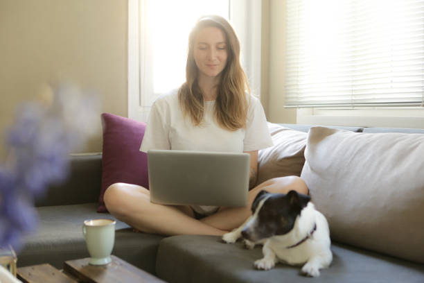 istock beautiful young woman using laptop 877633816